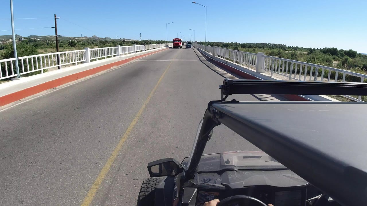 Jeep driving on an overpass with distant oncoming traffic.