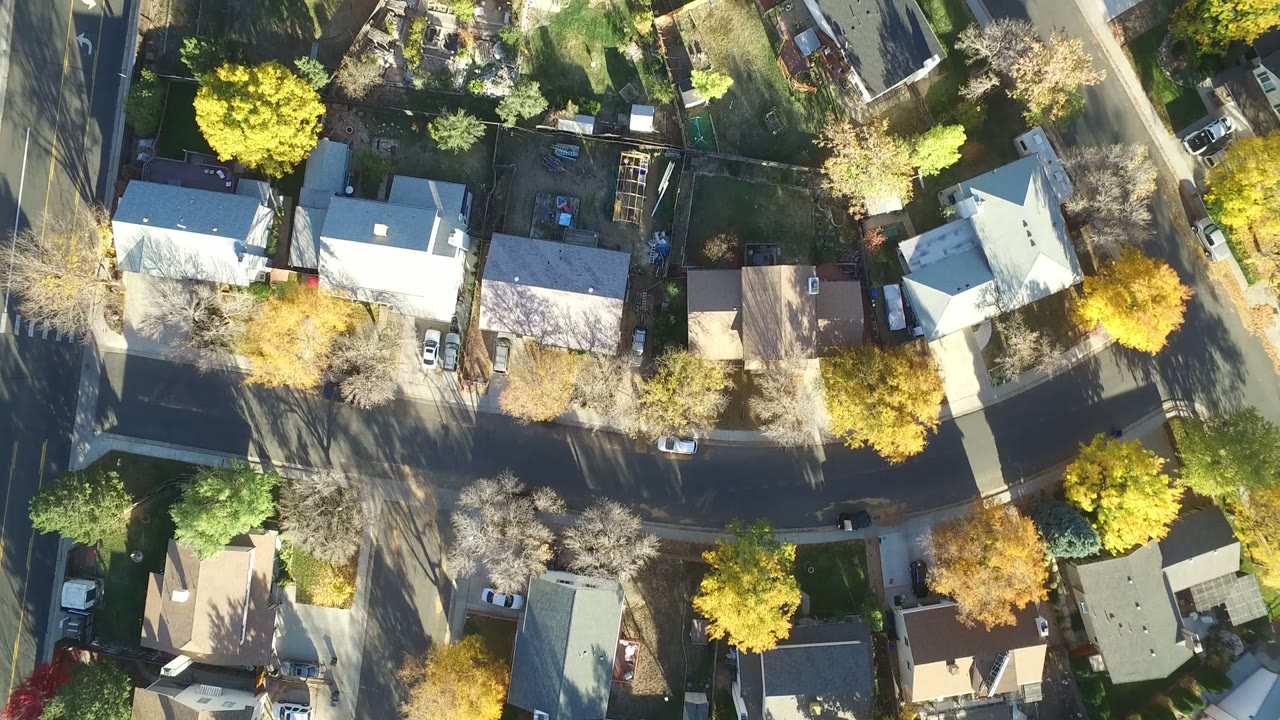 Top-down neighborhood view with rooftops, driveways, and tree-lined streets.
