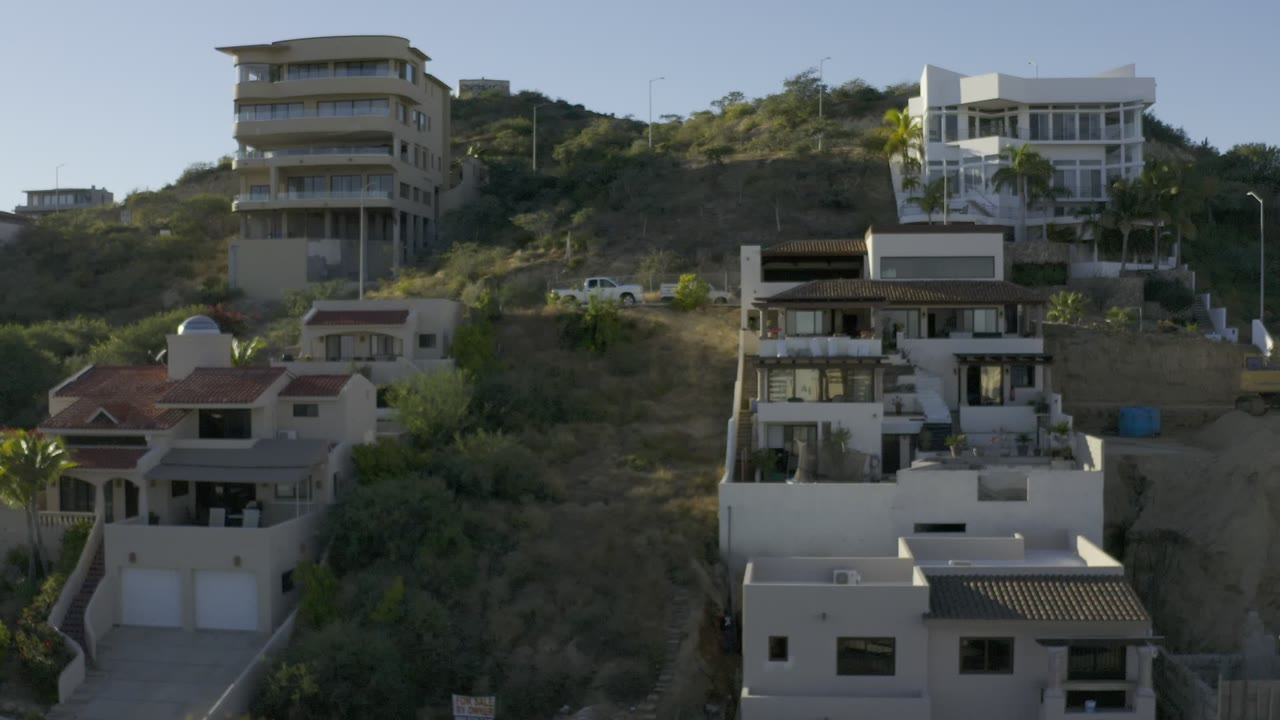 Hillside houses on a dry bluff under bright sun