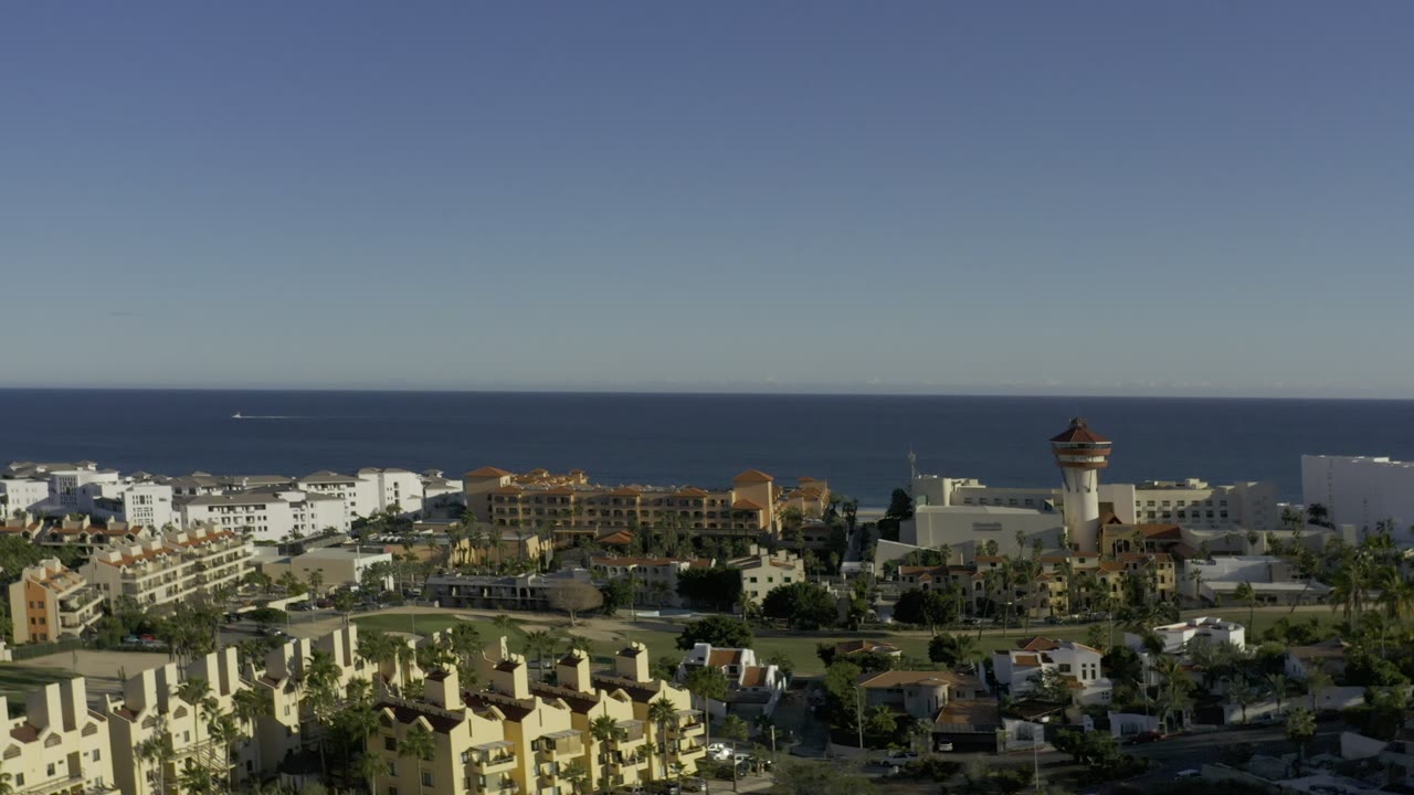Elevated coastal view over buildings and ocean horizon.