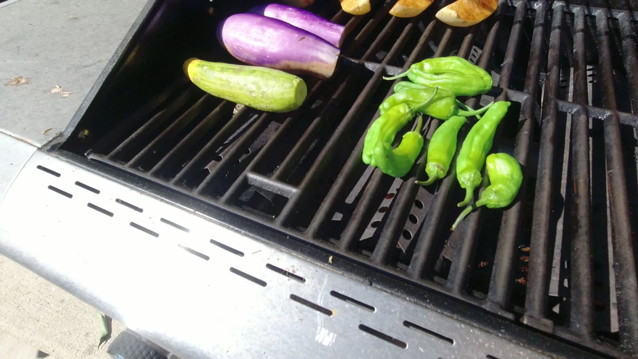 Vegetables cooking on an open grill grate.