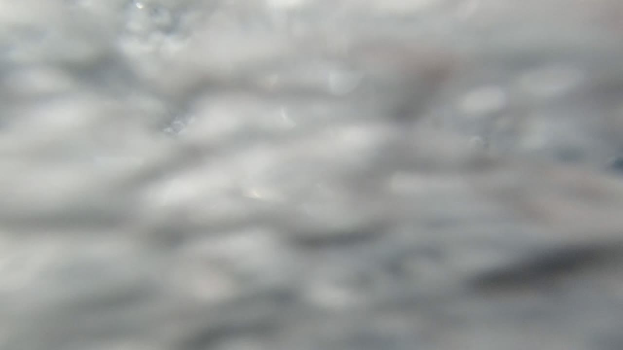 Blurred white bubbles fill the Los Cabos Mexico frame, with a darker blue patch near the right side and no visible people.