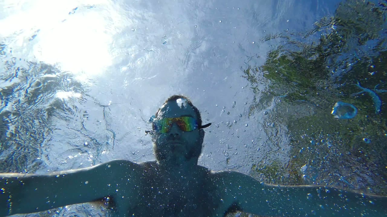 Man underwater with goggles near the water surface