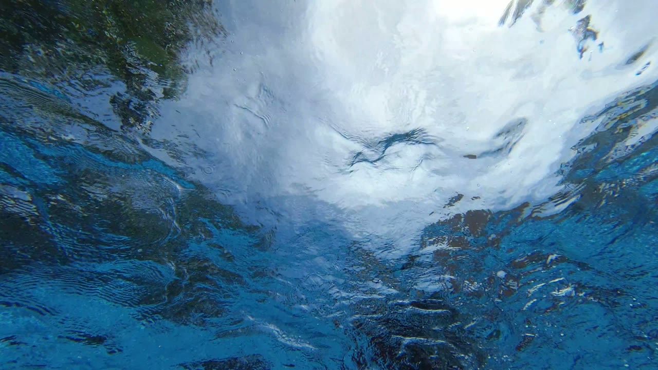 Rippling blue water in Los Cabos, Mexico with a large pale reflection spreading across the upper part of the frame and no visible people.