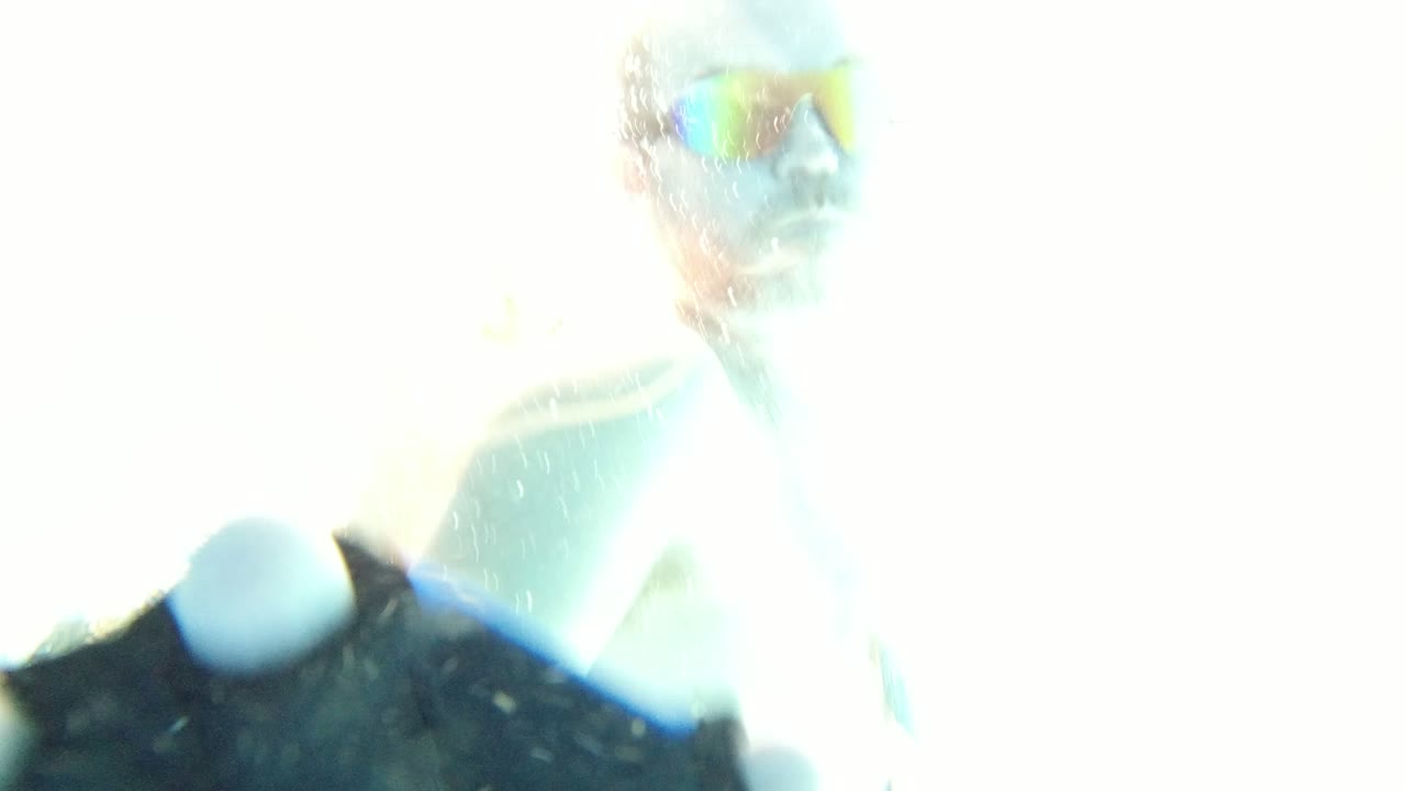 Overexposed swimmer above an underwater pool camera.