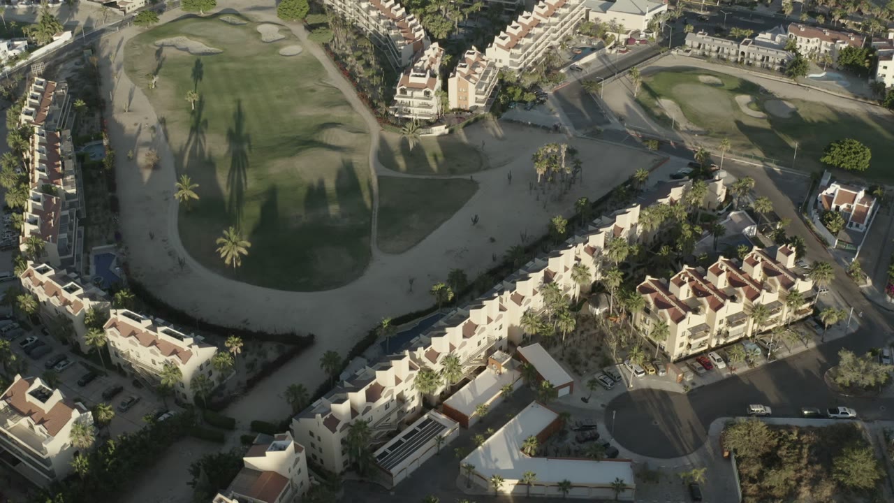 Aerial view of homes around a golf-course green and streets