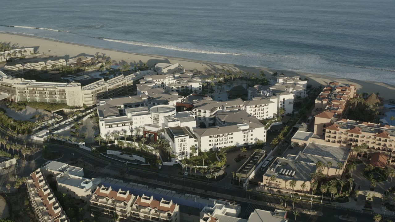 Aerial view of large coastal buildings beside a beach and ocean.