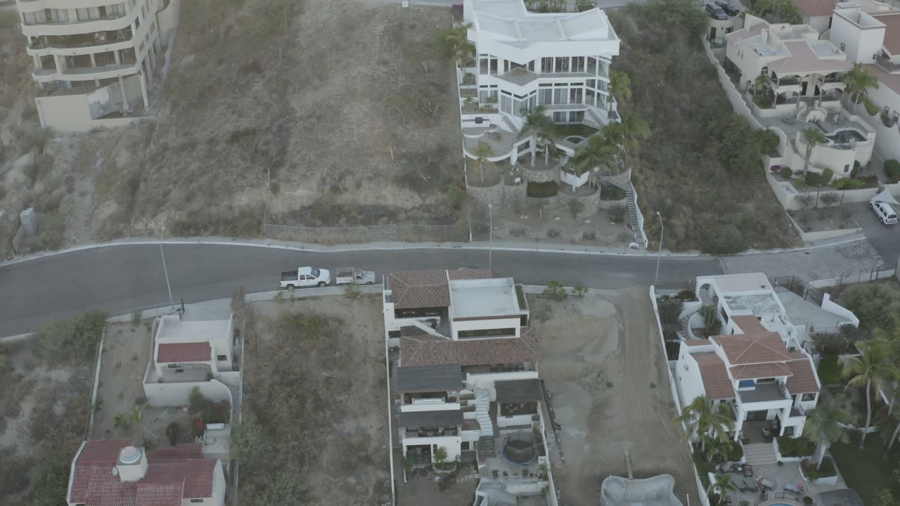 Aerial frame with houses, road, and dry hillside