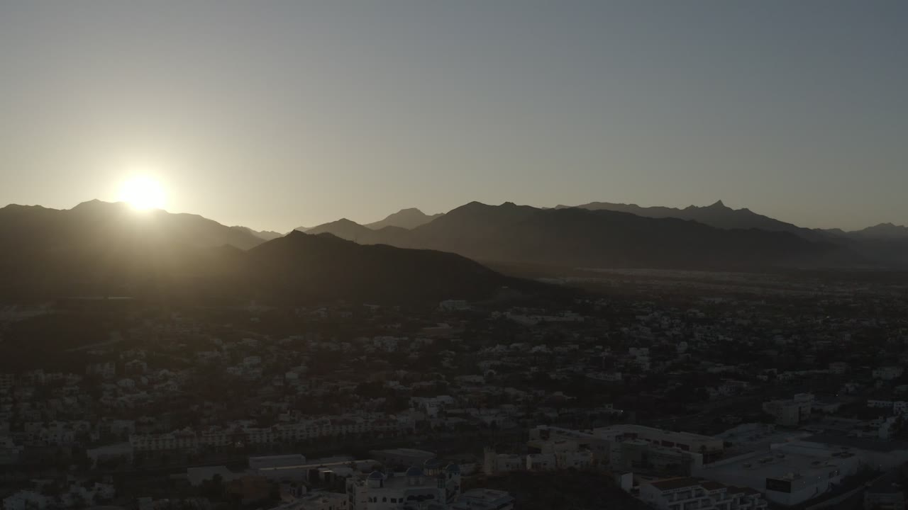 One second in, the sun remains bright above the ridge in Los Cabos, with layered mountains receding across the horizon and no visible people.