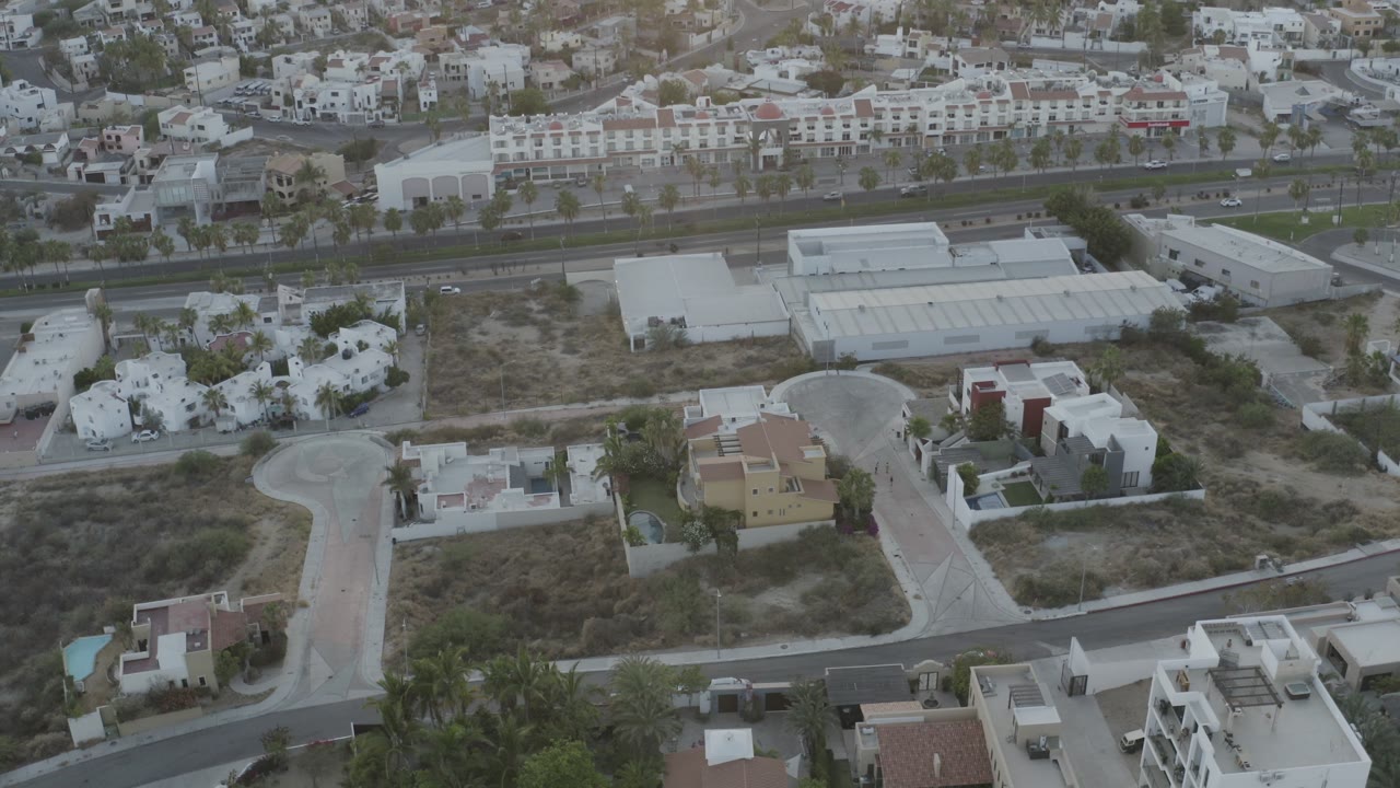 Overhead view of industrial buildings, villas, and a divided road.