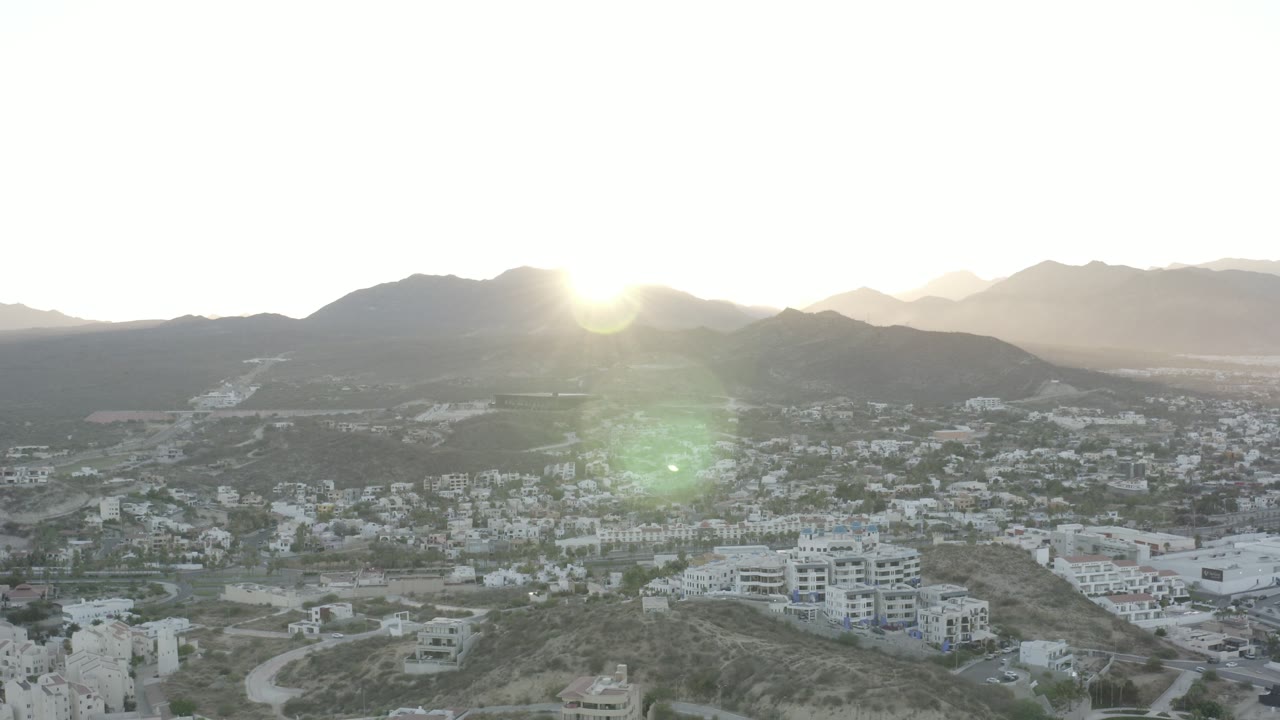 Residential hillside and valley town under low sun
