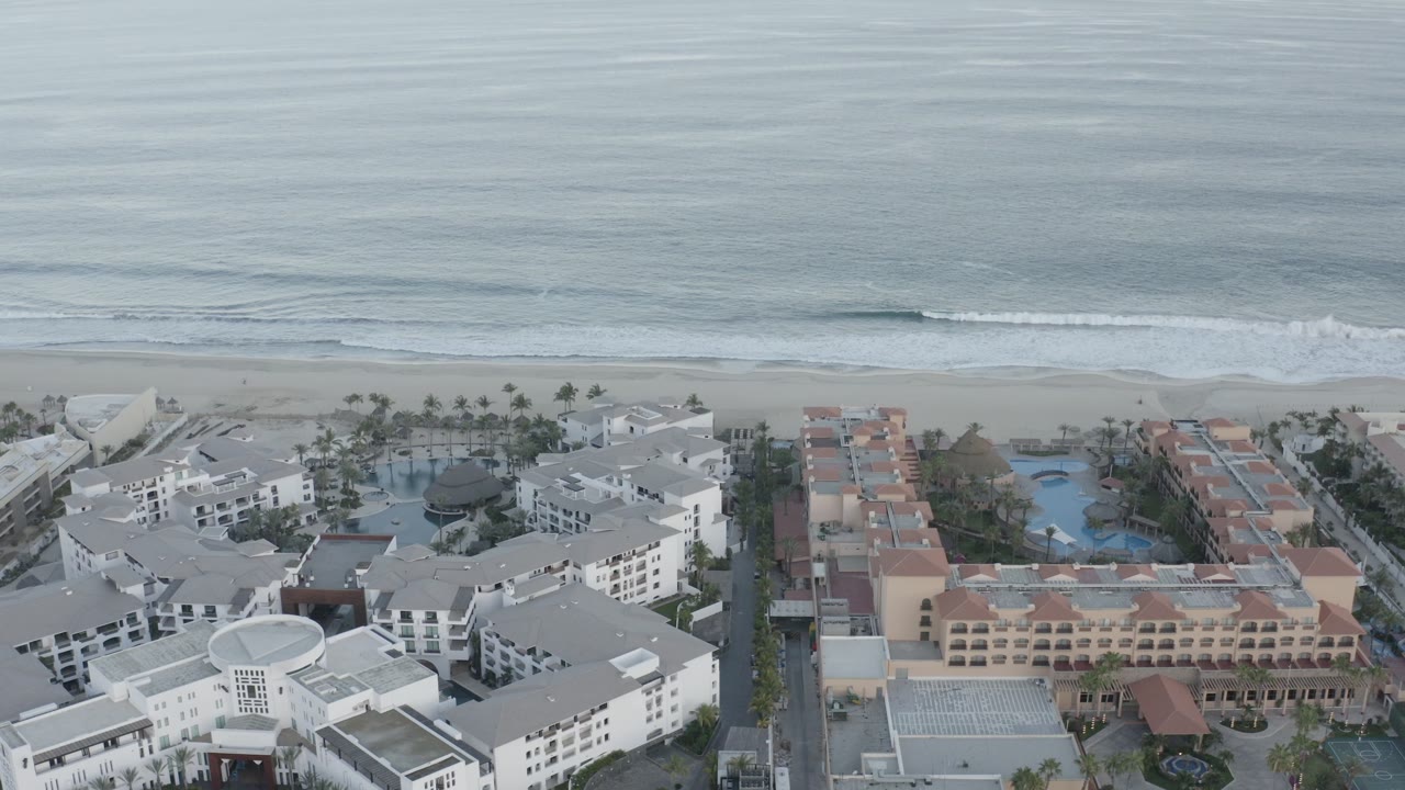 Aerial view of beachfront resort buildings beside calm ocean