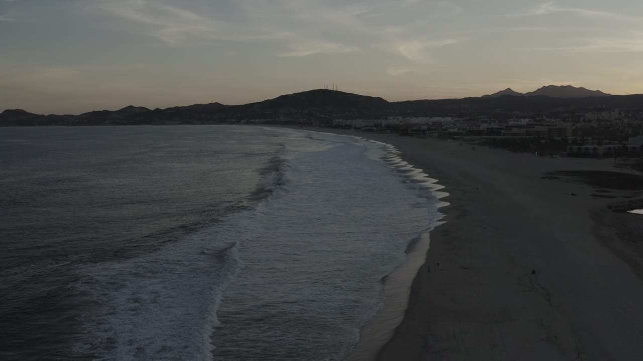 Elevated beach view with surf lines and distant mountains