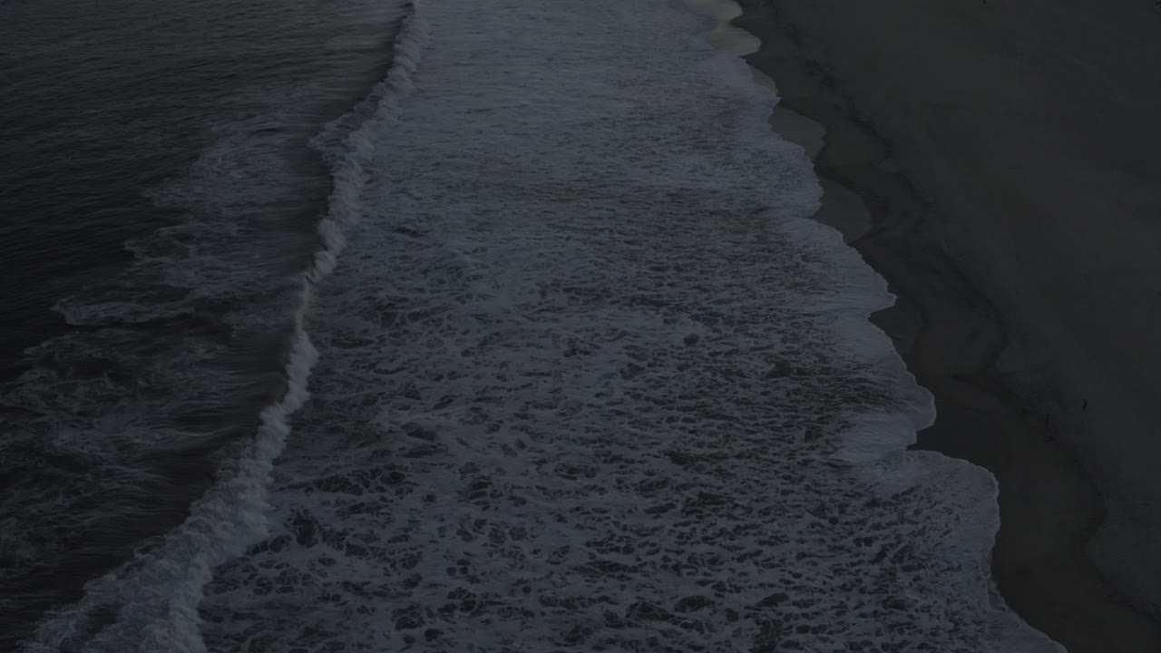 Diagonal surf line beside a nearly empty beach