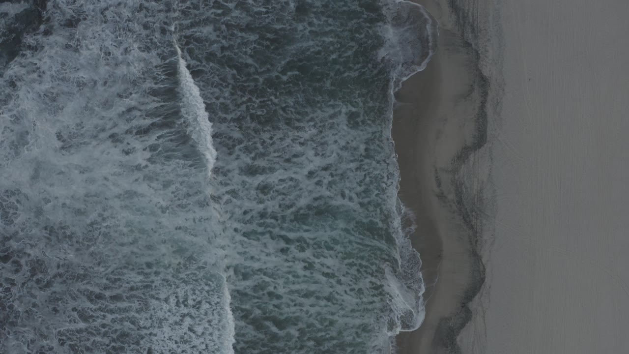 Foamy surf covering more of the shoreline
