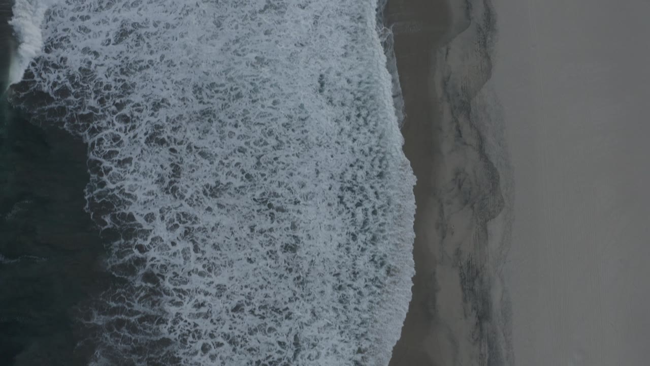 Breaking wave covers much of the shoreline.