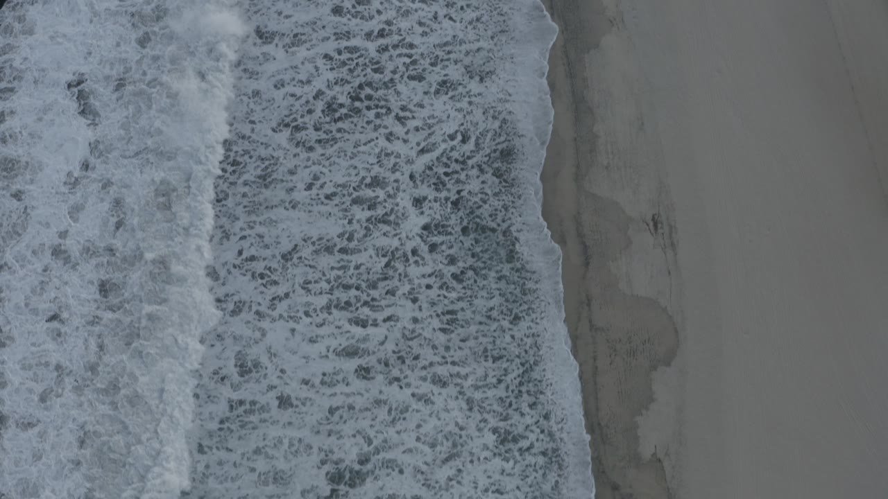 Foamy ocean edge beside empty beach