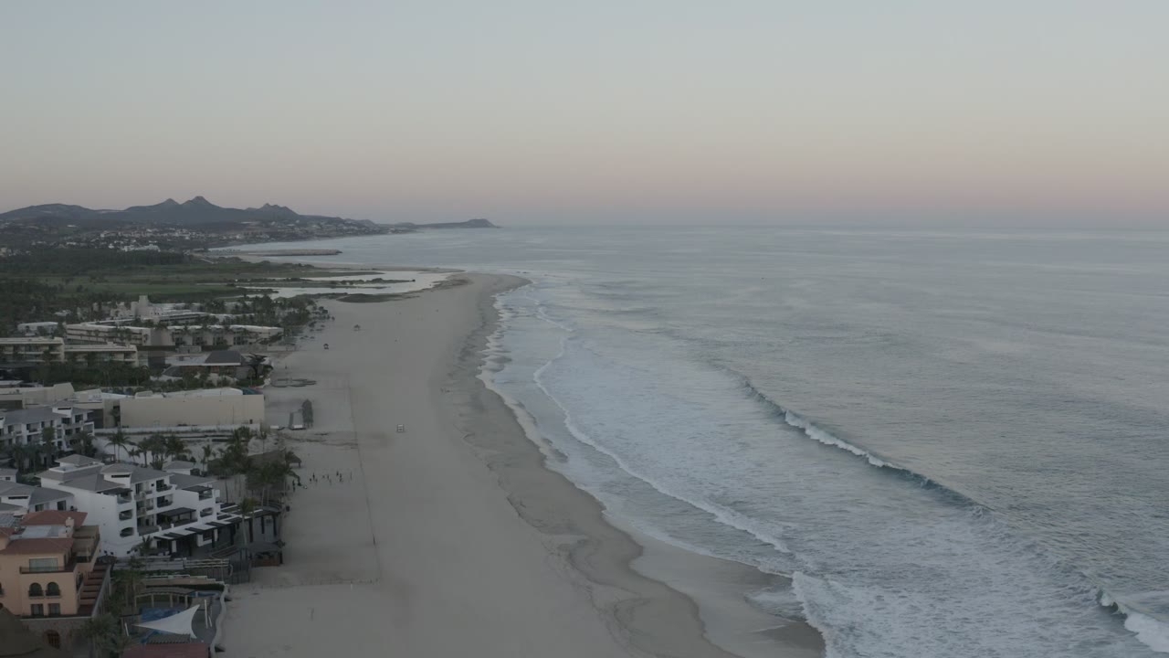 Elevated view of Los Cabos beach with waves and beachfront buildings
