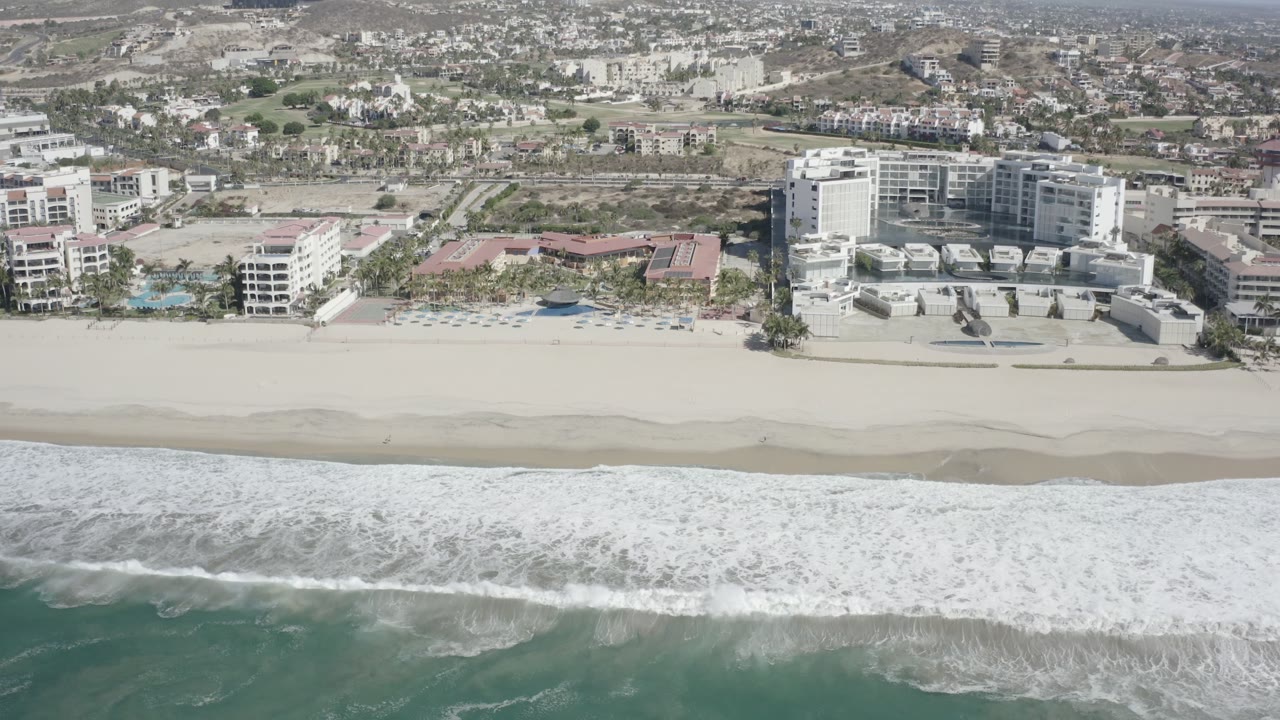Aerial view of surf, sandy beach, and beachfront hotels