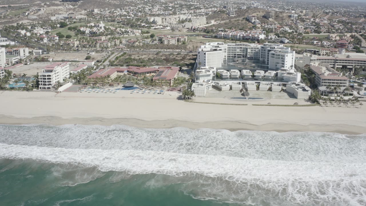Beachfront hotel complex seen from above with surf below.