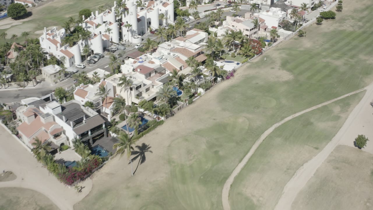 Aerial view of homes beside a golf course fairway.