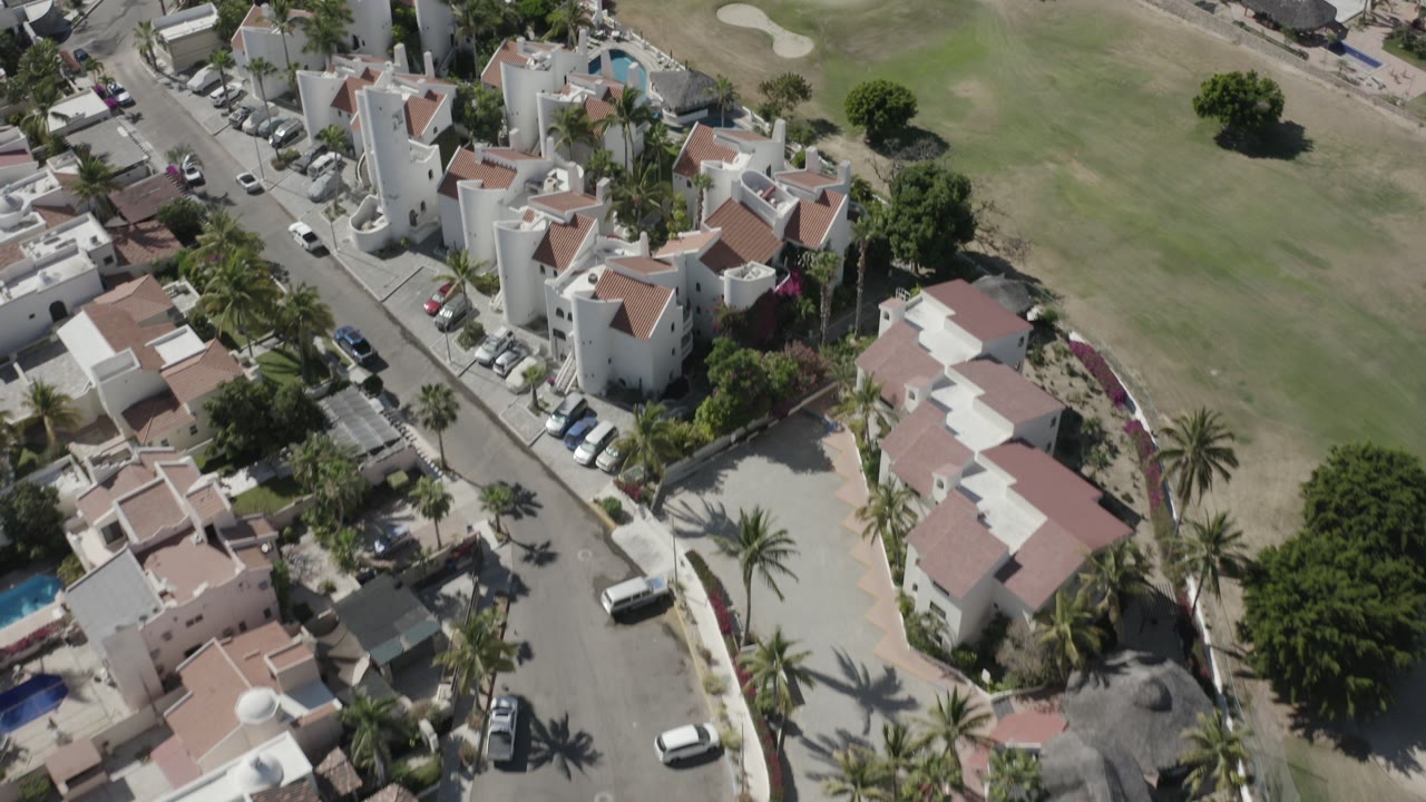 Aerial view of white villas beside a golf course