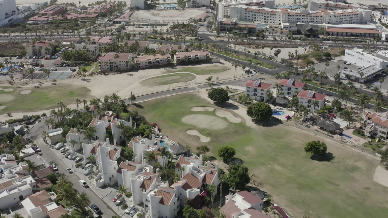 Aerial view of homes beside a golf course with sand traps.