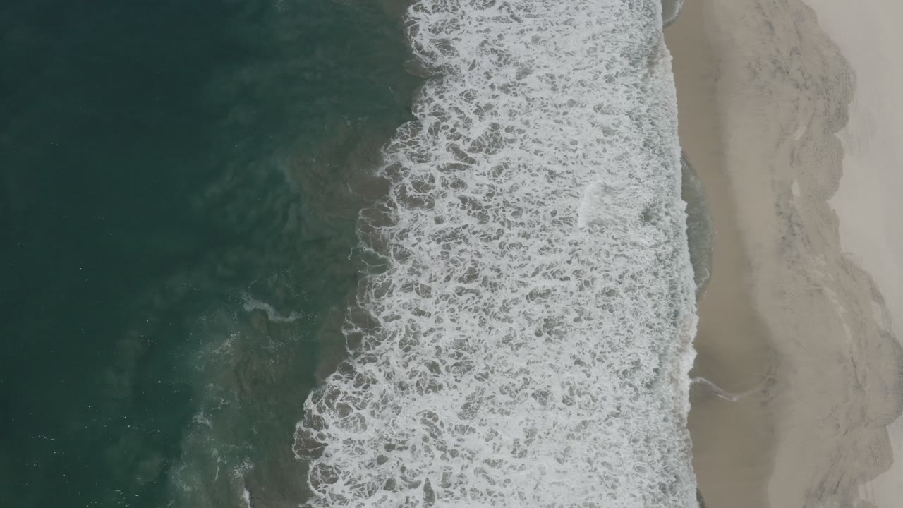 Diagonal ocean break against a deserted beach