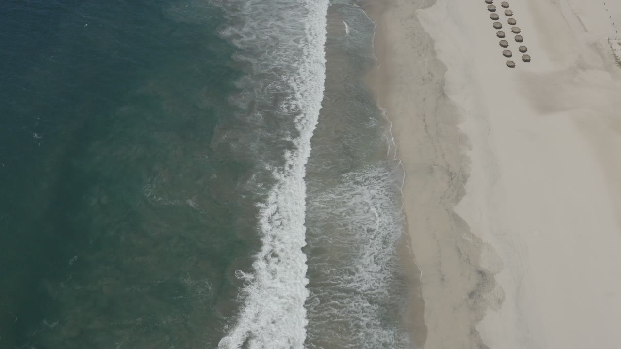 Aerial view of surf meeting a sandy beach