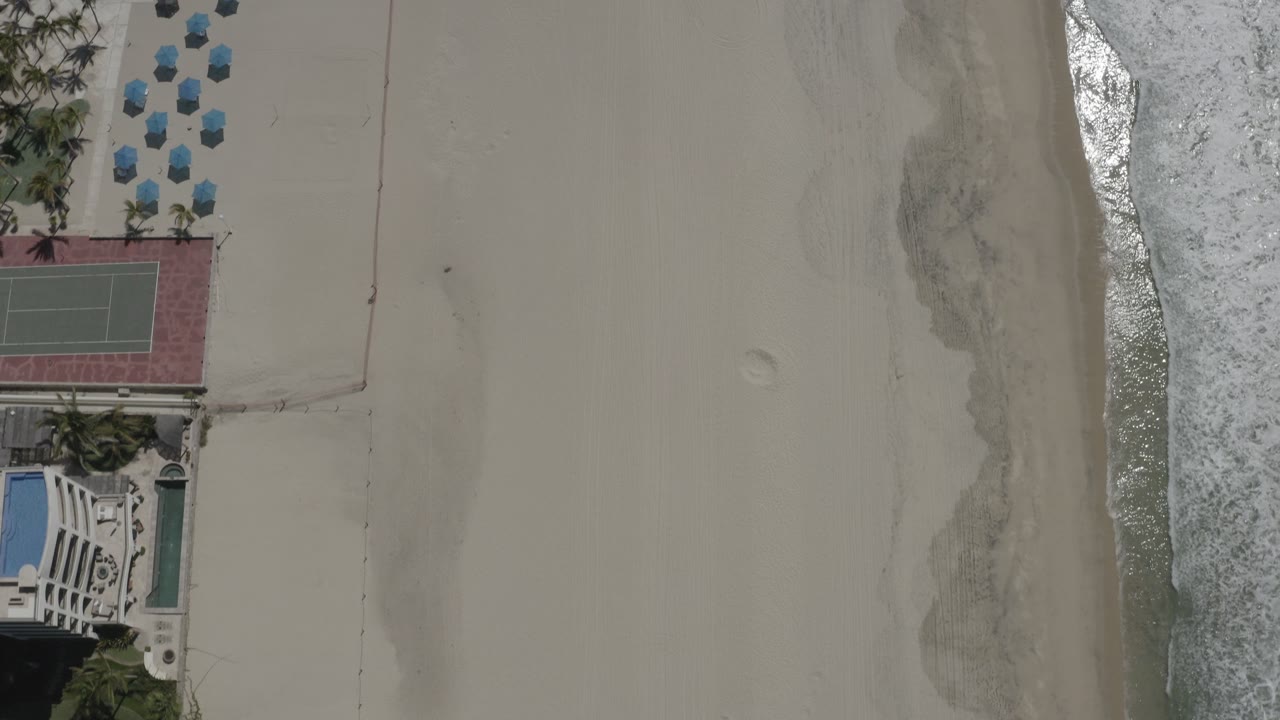 Aerial beach frame with mostly sand and water at the right edge