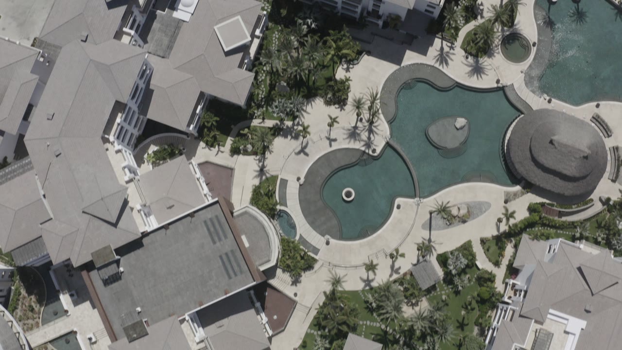 Overhead resort pool and hotel roofs with palm landscaping