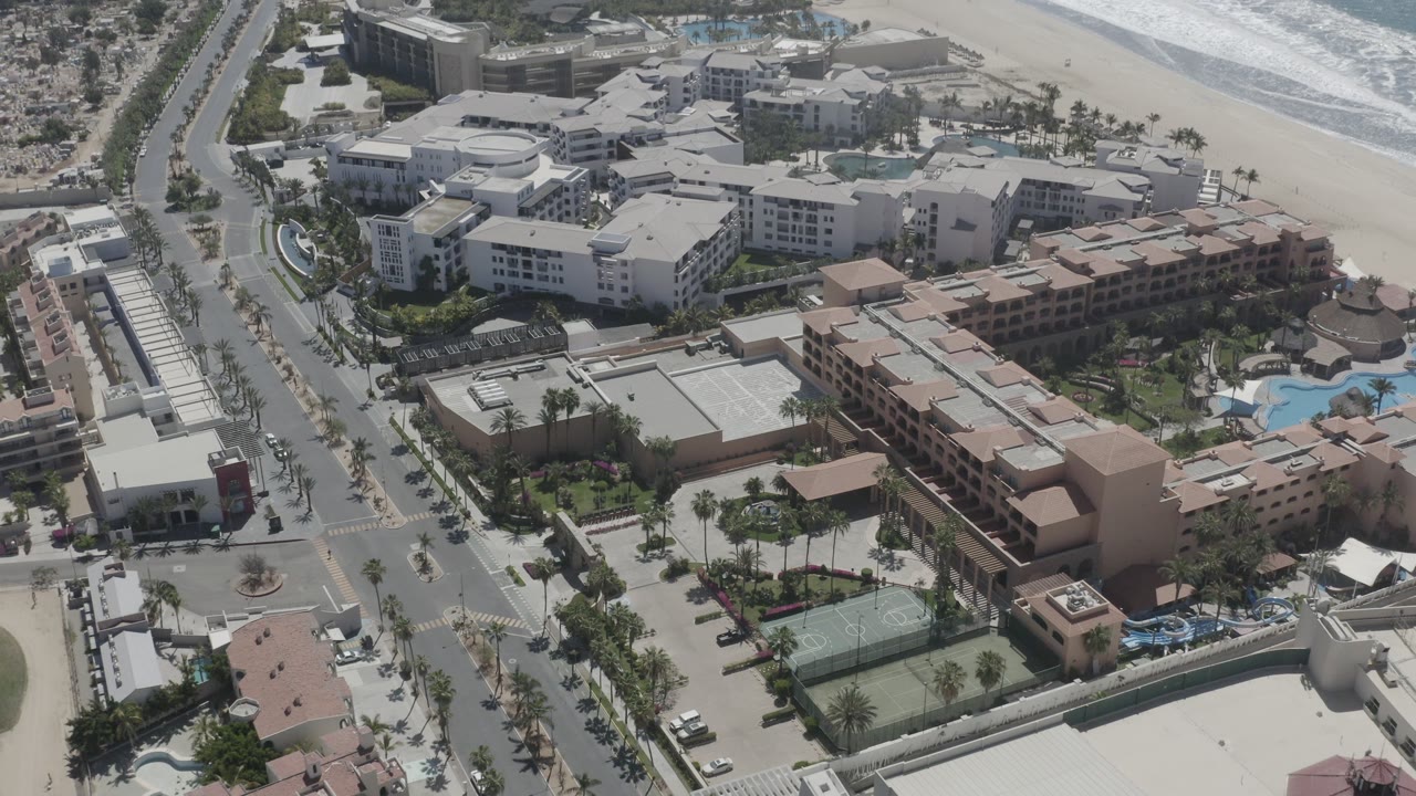 Aerial view of hotels, streets, beach, and ocean.