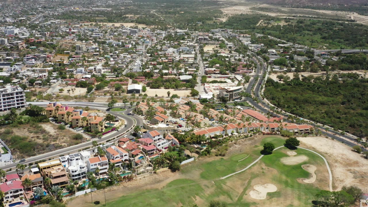 Aerial view of homes, roads, golf fairway, and dry hills