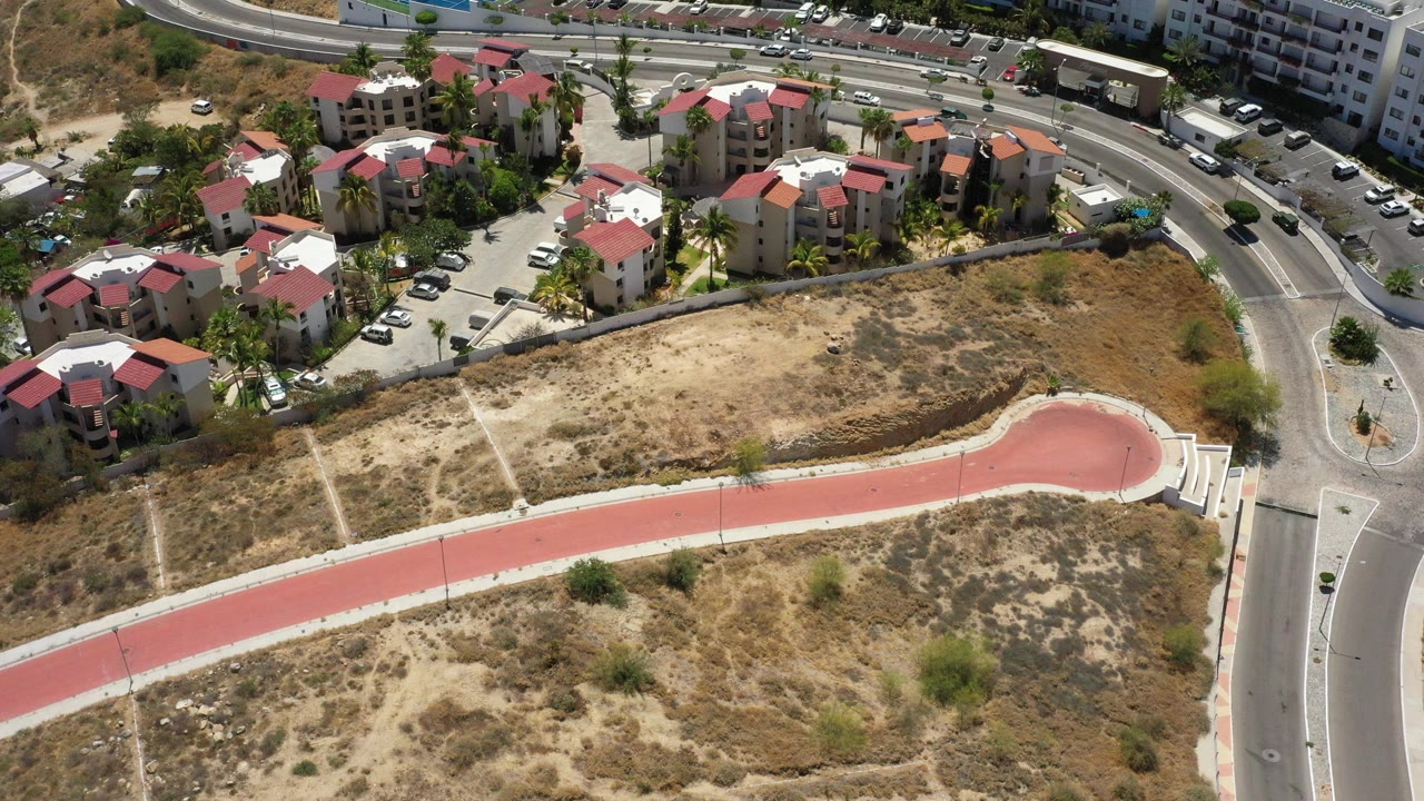 Aerial view of apartments, roads, and dry open lots.