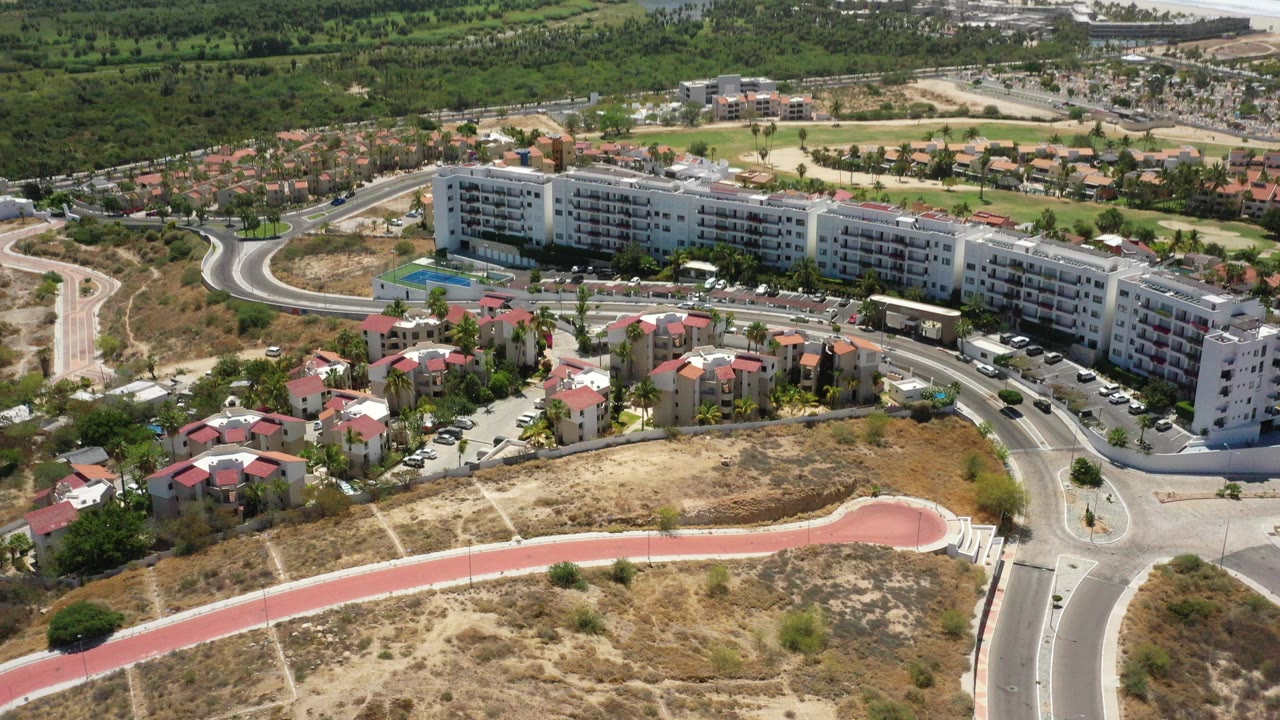 Aerial view of coastal buildings, roads, trees, and ocean.
