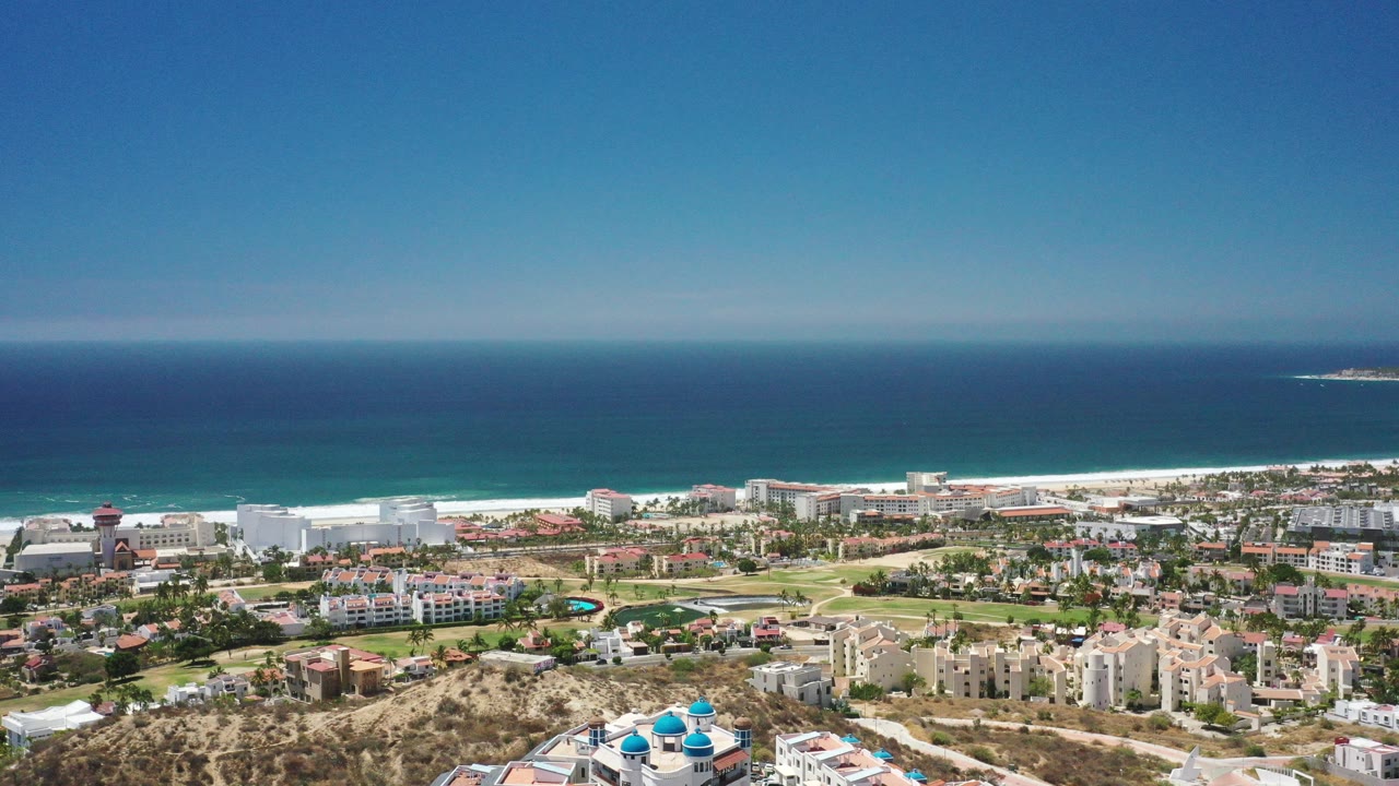 Aerial view over coastal buildings and blue ocean