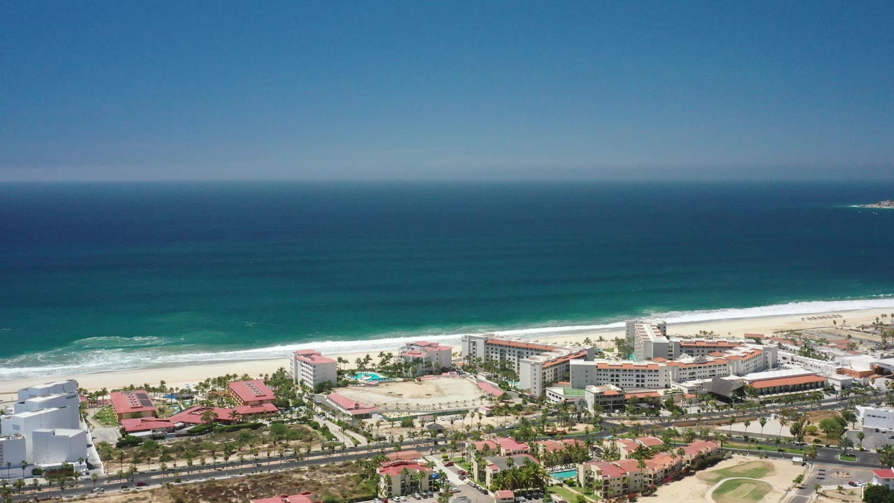 Wide coastal aerial with resorts and surf