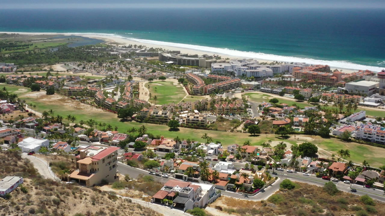 Elevated view of resort-area buildings, houses, roads, sand, and ocean shoreline