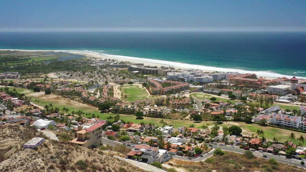 Aerial view of coastal homes, beach, and blue ocean