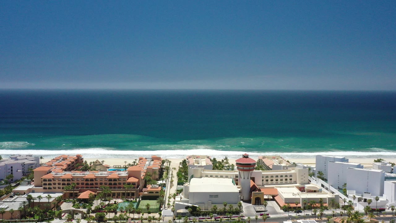 Aerial view of beachfront hotels and ocean surf.