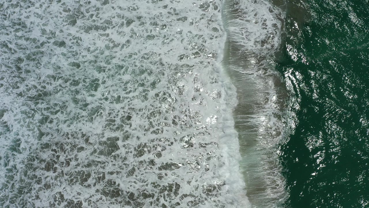 Overhead surf foam and green ocean water.