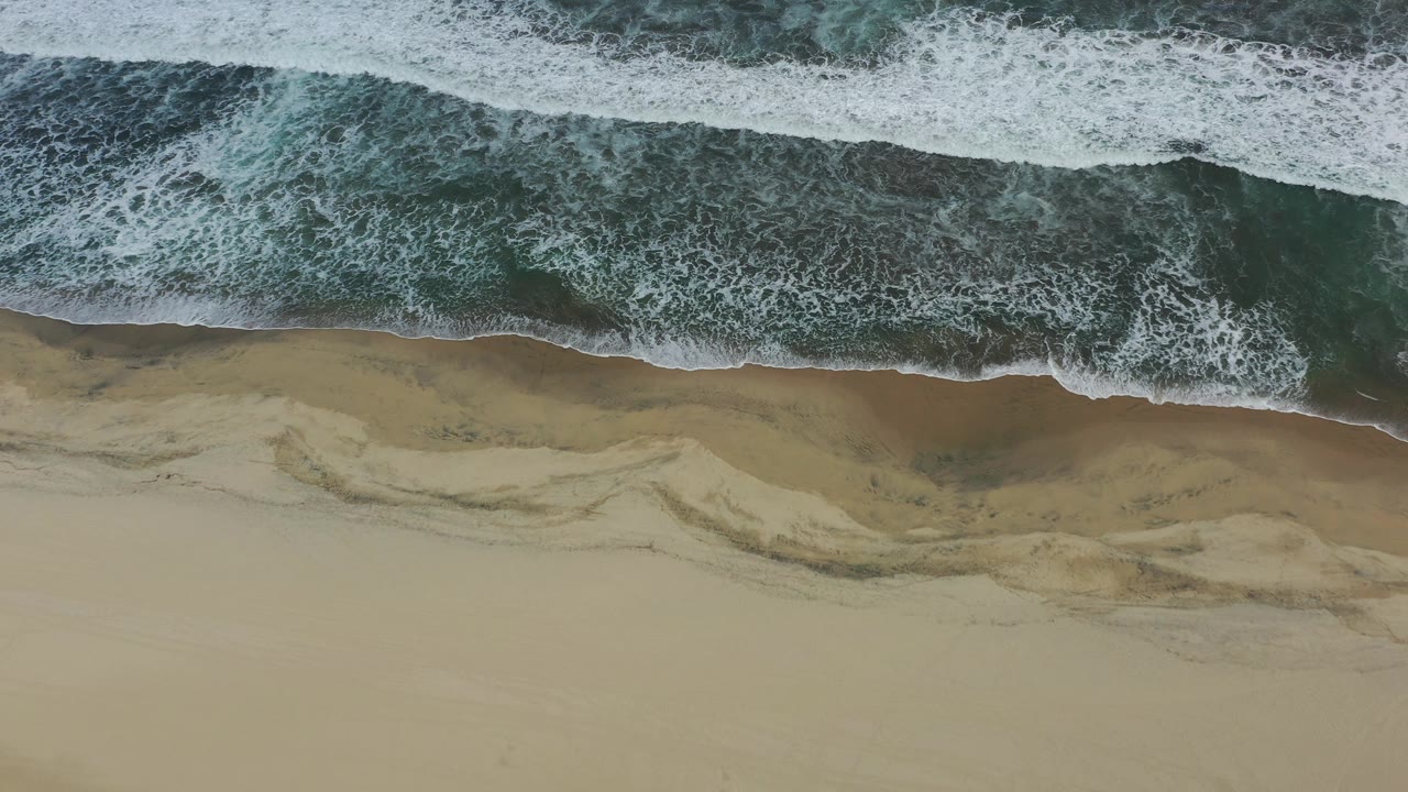 Aerial beach view with receding wave foam