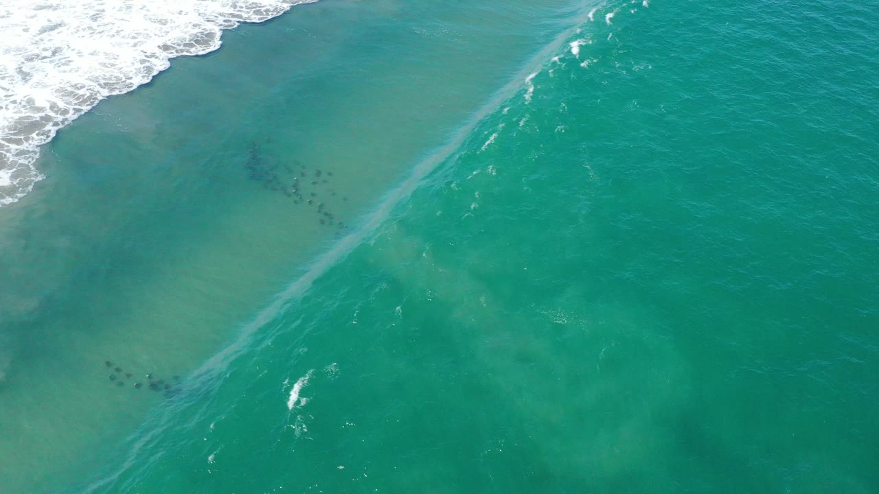 Diagonal wave line forming across turquoise water.
