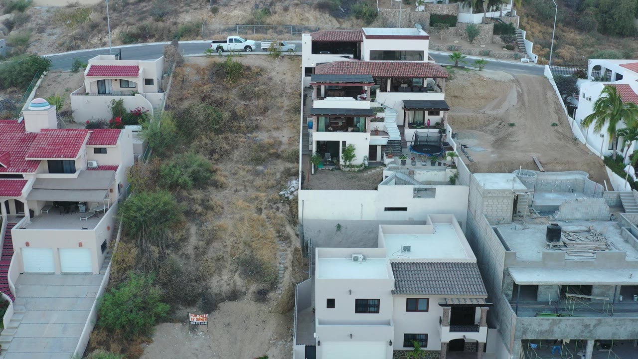 Aerial view of modern houses beside a dry hillside lot