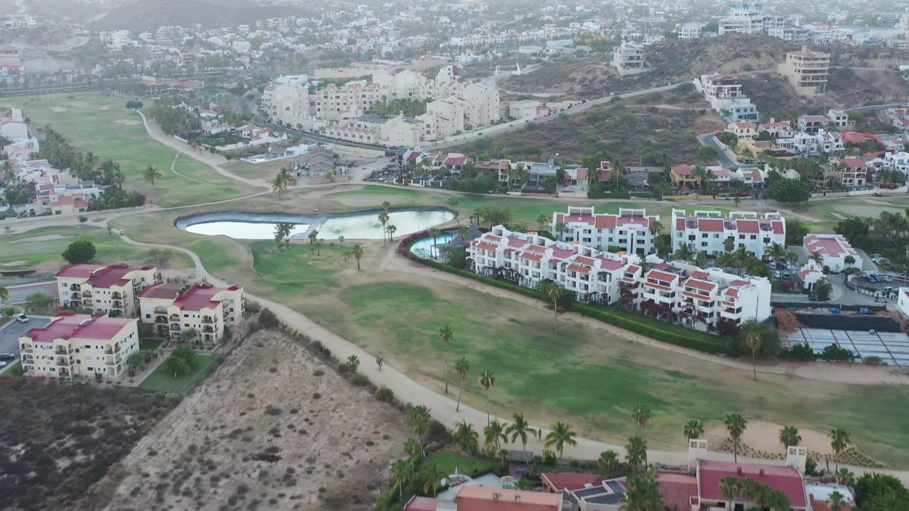 Aerial view of red-roofed residences beside green grounds and ponds