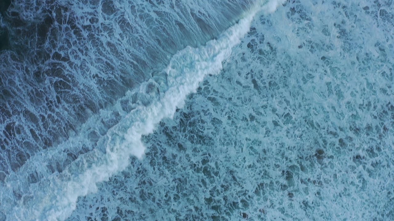 Foamy surf pattern over dark blue ocean