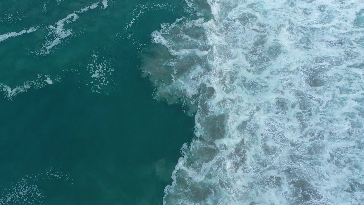 Breaking waves cover the right edge of a blue-green ocean view.
