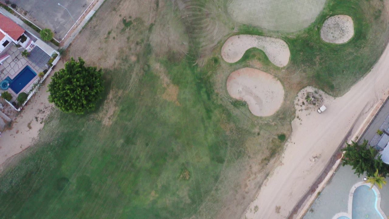 Overhead golf course with sand bunkers and nearby road