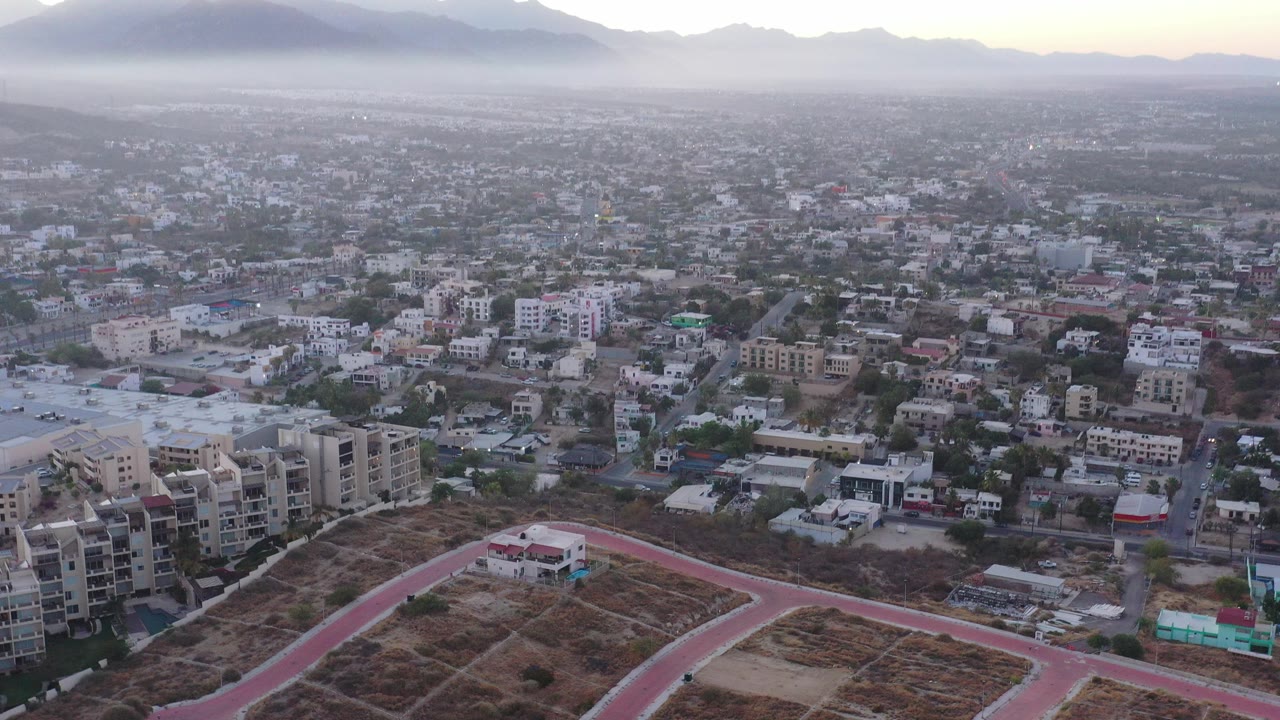 Aerial city view at dawn with mountains and haze on the horizon