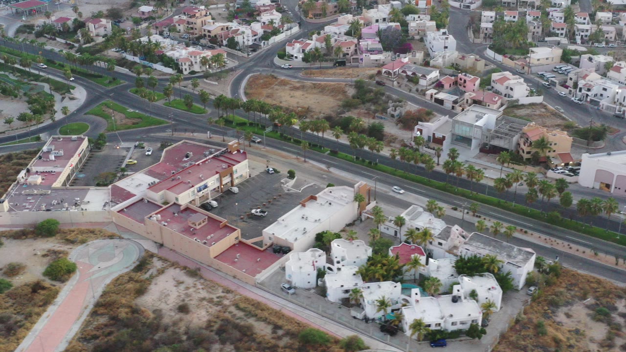 Aerial view of roads, homes, parking lot, and dry lots